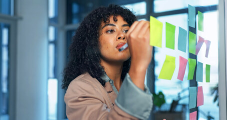 Obraz na płótnie Canvas Sticky notes, glass wall and businesswoman in office with planning for creative project ideas. Board, writing and magazine editor brainstorming with research for article at startup workplace.