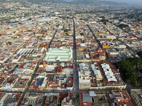 Aerial view of the historic city center of Oaxaca de Juarez, featuring colonial architecture, red-tiled rooftops, and the central market area in Oaxaca de Juarez, Oaxaca, Mexico.