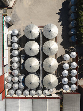 Aerial view of a tequila factory distillery featuring rows of large metallic storage tanks and industrial infrastructure in Tequila, Jalisco, Mexico.
