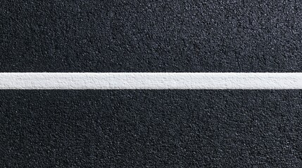 Fototapeta premium The White Line Across Rough Black Asphalt Creating Textured Road Surface