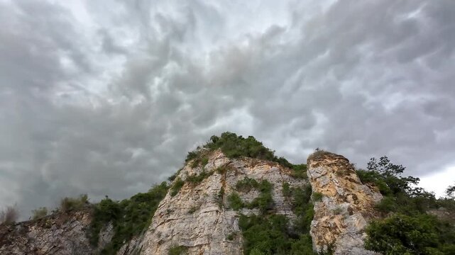 Rain clouds are moving along with the wind over the rocky mountains.
