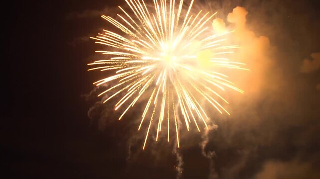 4K New year's eve fireworks celebration loop of real fireworks background. abstract golden shining glowing fireworks show.