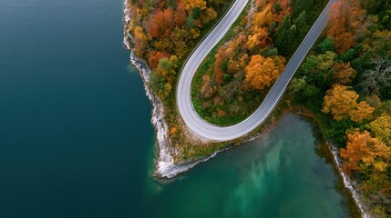 Obraz premium The Winding Road Through Autumn Forest Over Turquoise Lake Panorama
