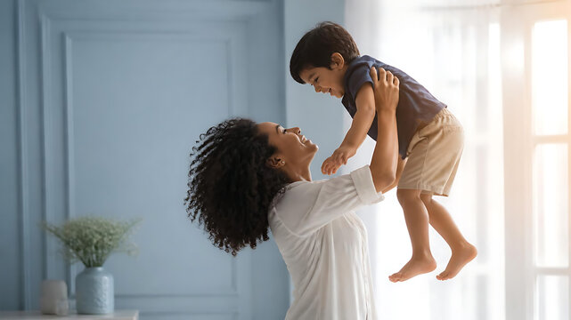 Elegant silhouette of a mother lifting her young child gently into the air near a sunlit window, soft glowing backlight, dreamy pastel blue and ivory atmosphere, joyful unconditional love