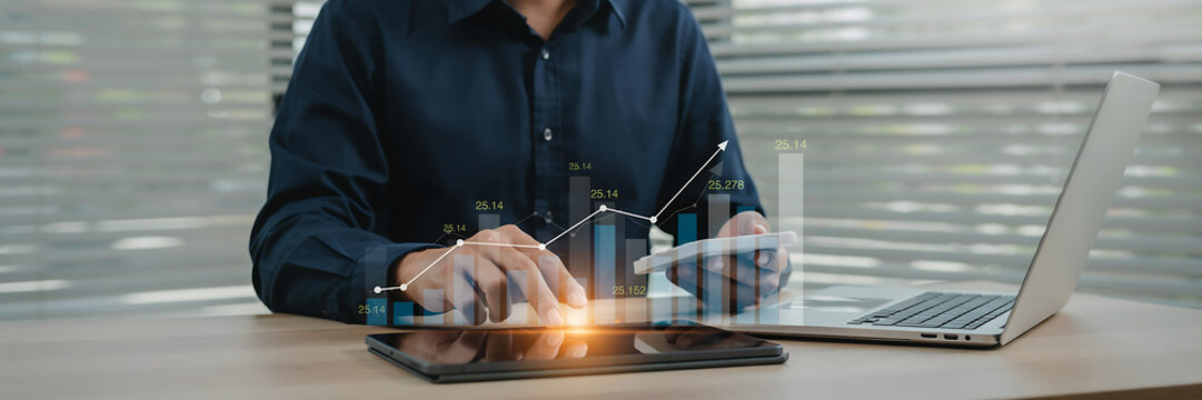 technology and busingess theme background Business professional analyzing data on tablet with laptop showing growth charts in office