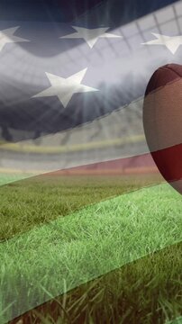 Waving american flag over multiple rugby balls falling against sports stadium in background