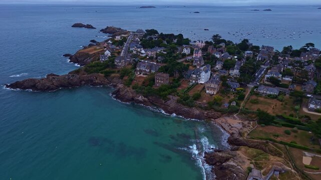 Drone flies above Saint-Lunaire, Ille-et-Vilaine, Brittany, France, revealing Longchamp Beach, the rocky Emerald Coast, Belle Epoque villas, coastal gardens and the English Channel.