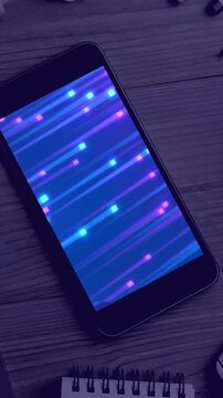 Animation of technological devices with light trails on screen on desk