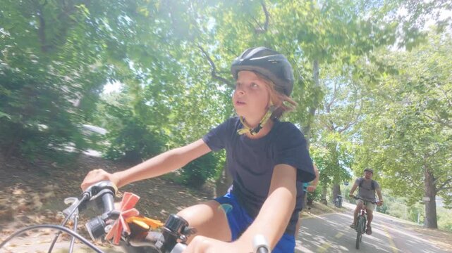 Happy Boy Riding Bicycle in Park with Family, POV View