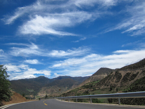 Scenic road with blue sky and white clouds in mountainous area