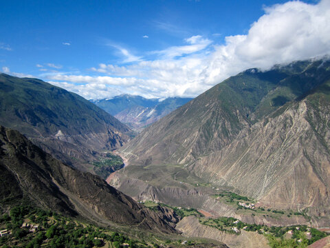 Vast mountain range with deep valley under clear blue sky