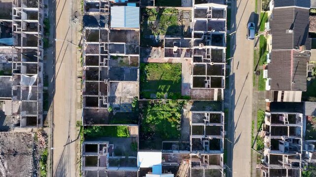 Top down view of rows of fire-damaged houses reduced to bare structural frames along a residential grid. Lirquen, Penco, Chile