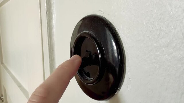 Finger Pressing Old Black Bakelite Light Switch