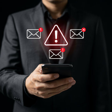 Executive holding smartphone with red exclamation mark and unread email message icons floating above.