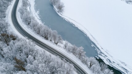 Obraz premium The Snowy Road Winding Through Frosty Trees Beside an Icy River
