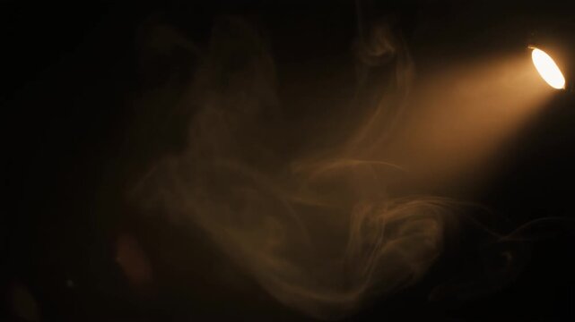 Warm light beam sweeps through drifting smoke, illuminating tendrils against deep black with dramatic cinematic contrast and clean negative space for text.
