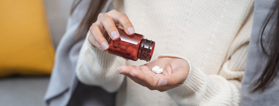 Close-up hands of person during take pills.