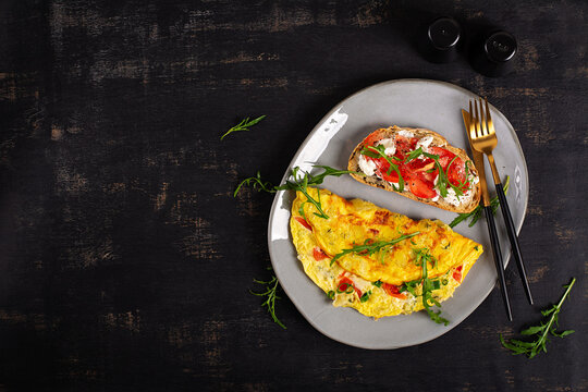 Homemade Omelette with Cheese and Tomato Toast on Dark Background