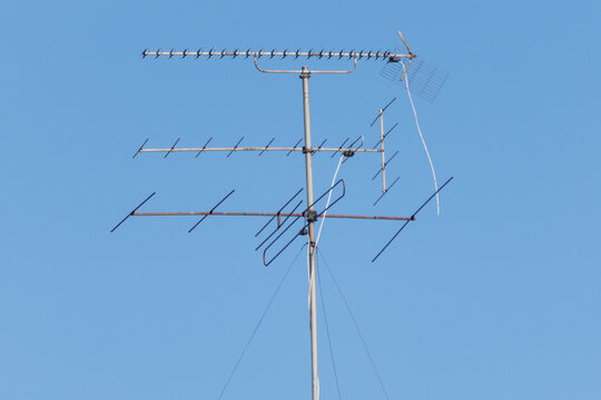 Metal antenna stands tall against clear blue sky