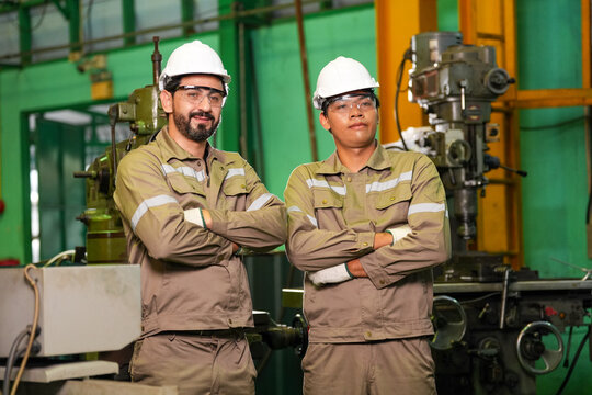 Engineer worker factory helmet safety glasses uniform Engineer worker factory team with helmet, safety glasses, uniform, industrial machinery, confident stance, manufacturing workplace