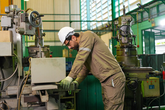 Engineer machine factory workshop helmet glove worker industrial metal safety, adult male operating machine in manufacturing workshop with protective gear and focused posture