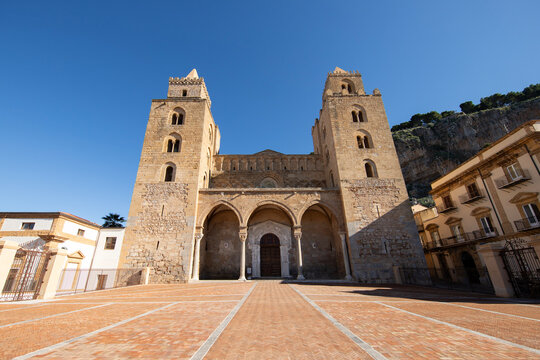 The Norman Cathedral of Cefalu stands majestically with its imposing stone facade.