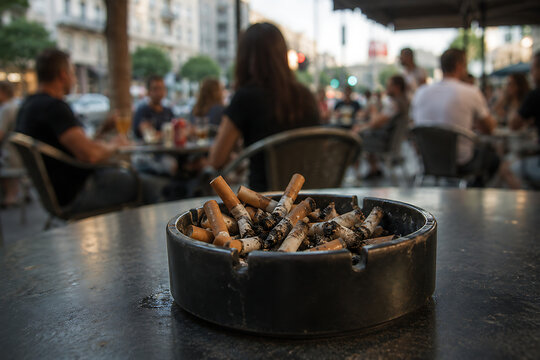 Ashtray full of cigarette butts on outdoor cafe terrace