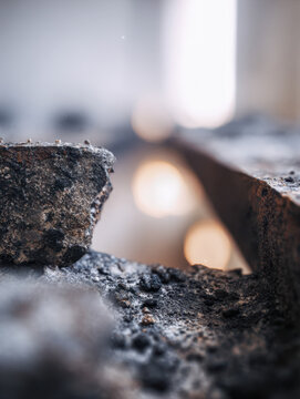 Texture and detail of a weathered rough concrete surface with shallow depth of field and soft blurred warm light in the background