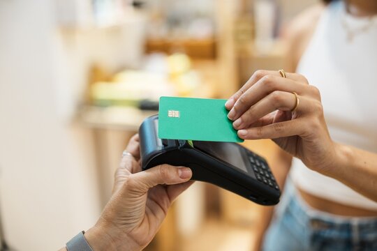 Customer making a green credit card payment at the store checkout with terminal checkout shopping customer