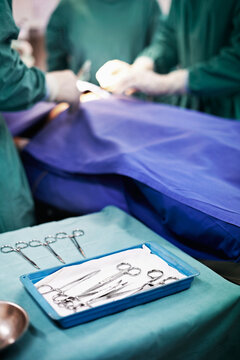 Theater, table and medical tools for surgery procedure, gastric bypass and operating precision. Surgeon team, people and scissors in ER for gastrectomy operation, sterile instruments and healthcare
