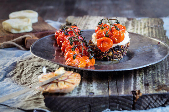 Roasted tomatoes, crostini with goat cheese, garlic on plate