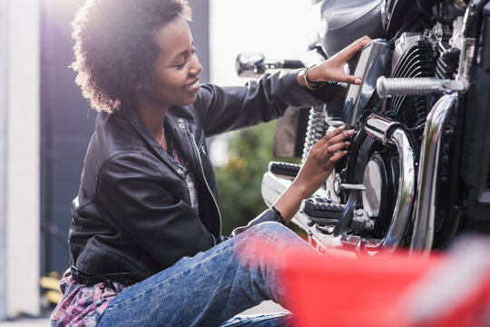 Young woman maintaining her motorcycle