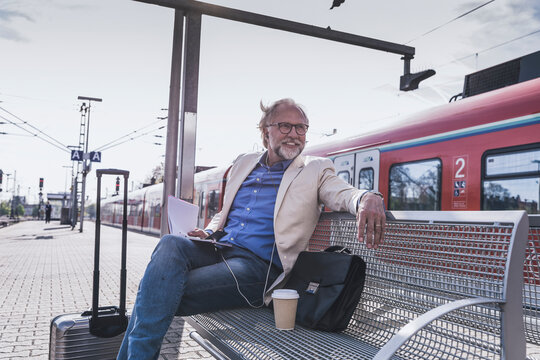 A businessman waits for a train at the railway station platform