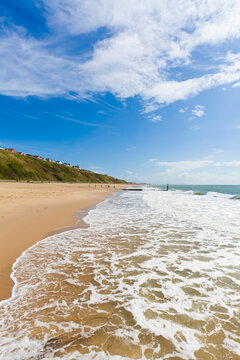 Waves wash ashore on the sandy beach of Bournemouth in Dorset
