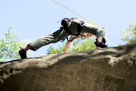 Young woman mountain climbing, low angle view