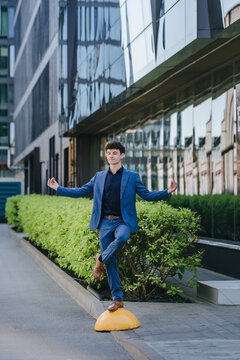 A businessman performs a yoga pose on a city street