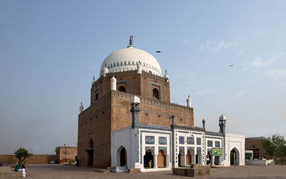 View of the historic Tomb of Hazrat Bahauddin Zakariya with its iconic white dome and intricate brickwork, set against a clear blue sky in Multan, Punjab, Pakistan.