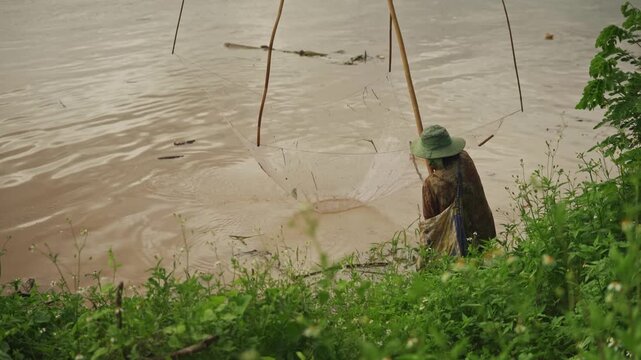 Woman Fishing with Traditional Dip Net Along the Mekong River, Rural Thailand, 4K Video Footage