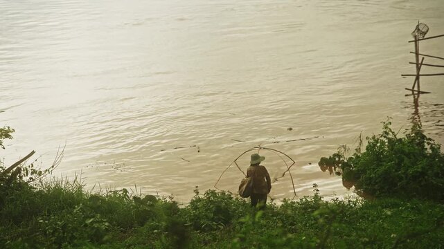 Woman Fishing with Traditional Dip Net Along the Mekong River, Rural Thailand, 4K Video Footage