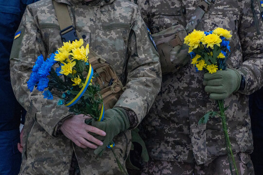 Ukrainian soldiers holding yellow and blue flowers