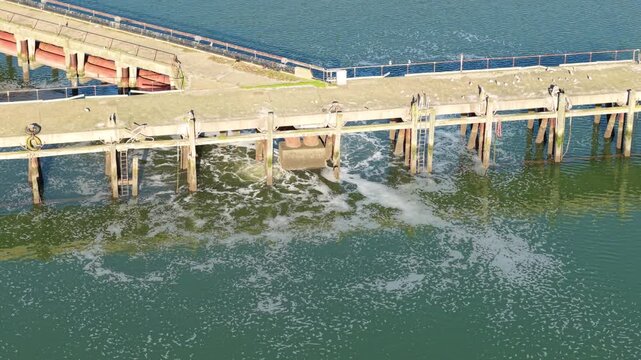 High angle aerial view of a wastewater treatment plant outfall pipe extending into the River Orwell