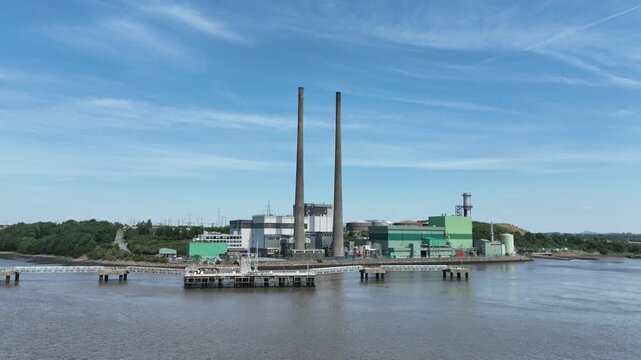 Cinematic drone flyover of hydroelectric power station along the River Suir in Wexford, Ireland. Clean energy production surrounded by lush countryside, captured in crisp 4K aerial video.