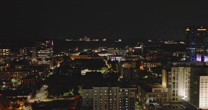 Raleigh North Carolina Aerial v50 low nighttime flyover above the Warehouse District toward downtown towers and glowing city streets - Shot with Inspire 3 8k - Sept 30th 2023