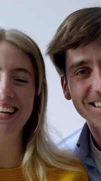 A joyful young couple, a man and a woman, smiling and laughing with sincere happiness. They share a close bond, enjoying a lighthearted moment together, captured in a warm and positive portrait.