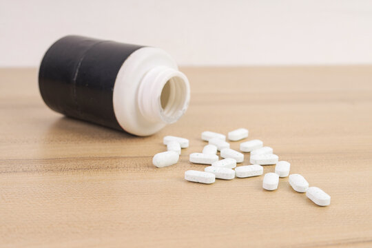 Close Up of Medical Pills Spilled from Open Container