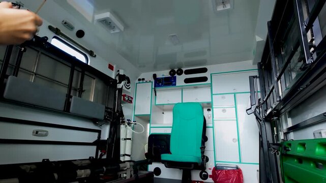 A wideangle interior shot of a clean, modern ambulance vehicle featuring medical storage, oxygen tanks, and paramedic seating. Suitable for healthcare and emergency service themes.