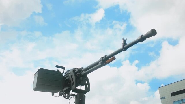 A low angle shot of a large caliber machine gun mounted on an armored vehicle turret, suitable for defense and military documentary content.