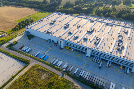 Aerial view of amazon logistics warehouse with many semi-trailer trucks at loading docks