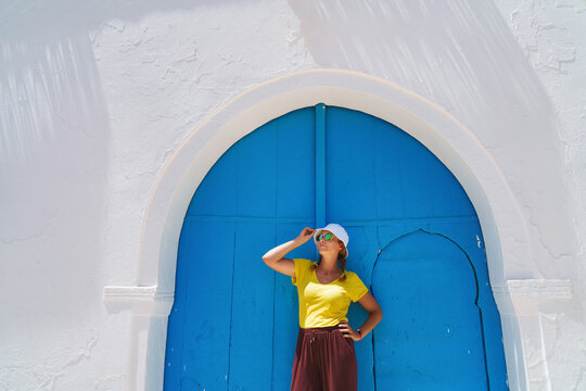 A female tourist in Tunisia &ndash; Island of Djerba &ndash; blue door in old town.