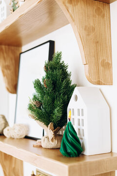 Decorative Christmas items are placed on a wooden shelf during the holiday season in a cozy living space